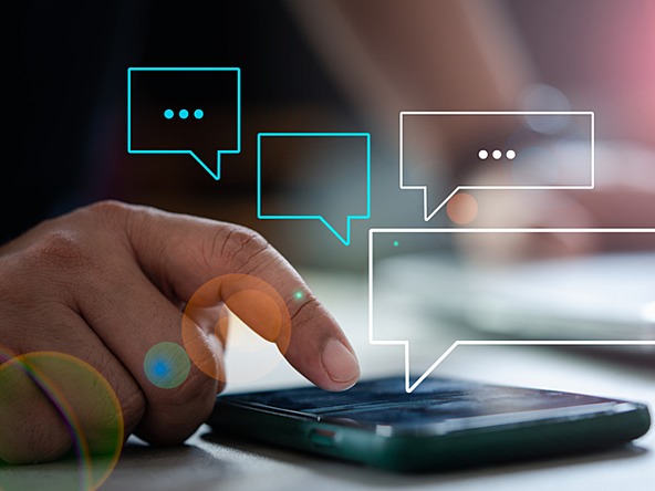 hand using smartphone with messaging and speech bubble icons floating above 